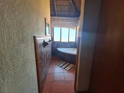 a bathroom with a bath tub and a window at Hornbill Private Lodge Mabalingwe in Mabula