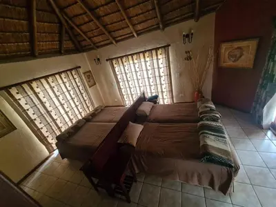 a large bed in a room with two windows at Hornbill Private Lodge Mabalingwe in Mabula
