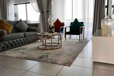 a living room with a couch and a table and chairs at Luxury Penthouse Apartment at the Blyde Pretoria in Pretoria