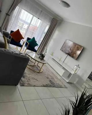 a living room with a couch and a table at Luxury Penthouse Apartment at the Blyde Pretoria in Pretoria
