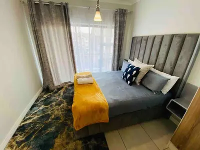 a bedroom with a bed with a wooden headboard at Luxury Penthouse Apartment at the Blyde Pretoria in Pretoria