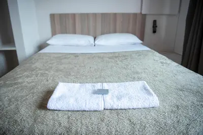 a pair of beds with towels on the bed at Ecomotel Kempton Park in Kempton Park