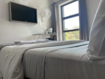 a bedroom with a bed with a television on the wall at Ecomotel Kempton Park in Kempton Park
