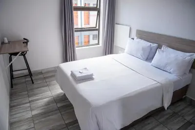 a white bed with a book on it in a room at Ecomotel O.R.Tambo in Kempton Park