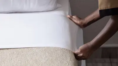 a person standing on top of a bed at Ecomotel O.R.Tambo in Kempton Park