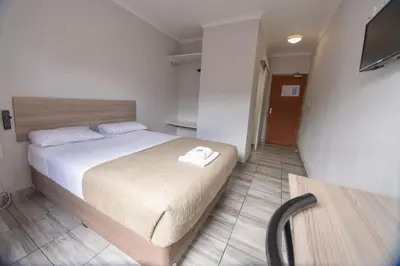 a bedroom with a bed and a television in it at Ecomotel O.R.Tambo in Kempton Park