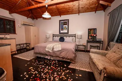 a bedroom with a bed and a couch at Thulamela Couples Retreat in Hazyview
