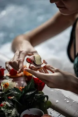 a woman is holding a sandwich on a table at Thulamela Couples Retreat in Hazyview