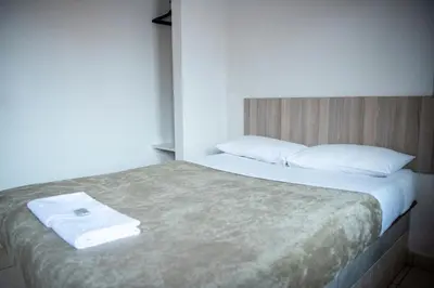 a bedroom with a bed with white sheets and pillows at Ecomotel Isando in Kempton Park