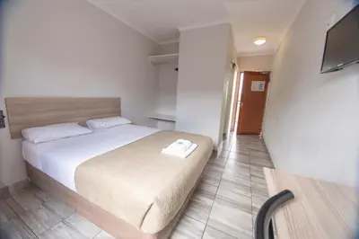 a bedroom with a bed and a television in it at Ecomotel Isando in Kempton Park