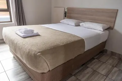 a bed with two towels sitting on top of it at Ecomotel Isando in Kempton Park