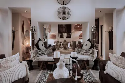 a living room with a table and chairs and a mirror at African Flair Boutique Safari Lodge in Hoedspruit