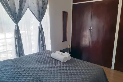 a bedroom with a bed with two towels on it at Queens Palace in Pretoria