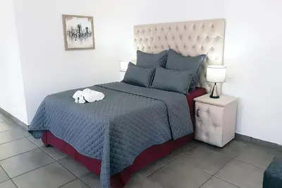 a bedroom with a bed with a blue comforter at Queens Palace in Pretoria
