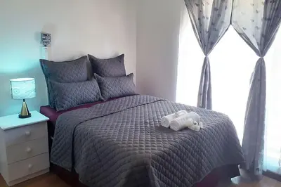 a stuffed animal laying on a bed in a bedroom at Queens Palace in Pretoria