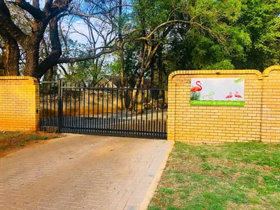 a yellow brick fence with a sign on it at Grafiti Boutique Hotel in Bela-Bela