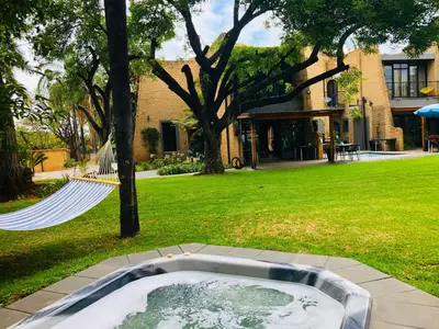 a hot tub in a yard next to a house at Grafiti Boutique Hotel in Bela-Bela