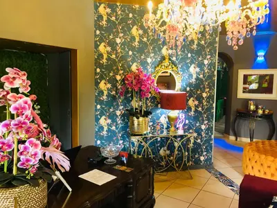 a room with a table and flowers on a wall at Grafiti Boutique Hotel in Bela-Bela