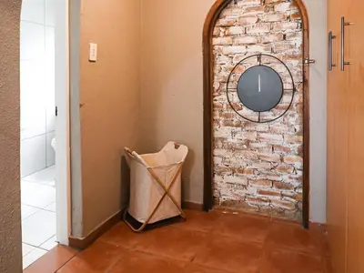 a hallway with a brick wall and a mirror at 16 Vaalrivier in Secunda