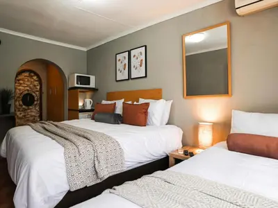 a hotel room with two beds and a mirror at 16 Vaalrivier in Secunda