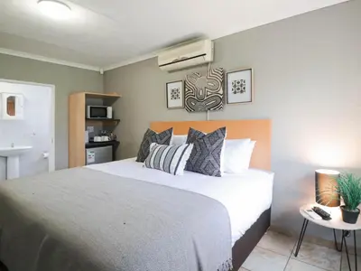 a bedroom with a large bed with pillows at 16 Vaalrivier in Secunda