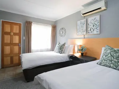 a hotel room with two beds and a window at 16 Vaalrivier in Secunda