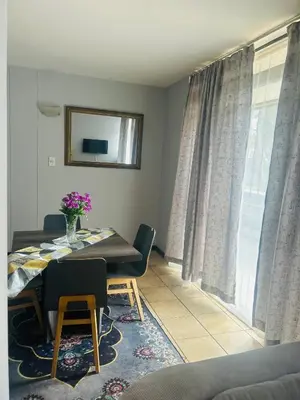 a dining room with a table and a window at Menlyn Place Haven in Pretoria