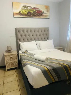 a bedroom with a bed with two cars on the wall at Menlyn Place Haven in Pretoria