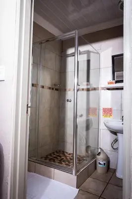 a glass shower in a bathroom with a sink at Lempitse Lodge in Moletlane