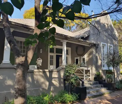 a house with a tree in front of it at Waterhouse Guest Lodge in Muckleneuk in Pretoria