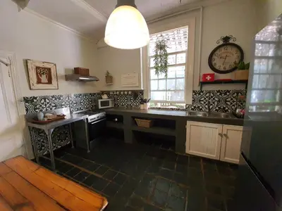 a kitchen with a counter and a clock on the wall at Waterhouse Guest Lodge in Muckleneuk in Pretoria