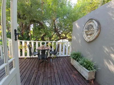 a wooden deck with a table and chairs on it at Waterhouse Guest Lodge in Muckleneuk in Pretoria