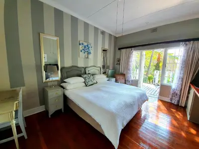 a bedroom with a large bed and a large window at Waterhouse Guest Lodge in Muckleneuk in Pretoria