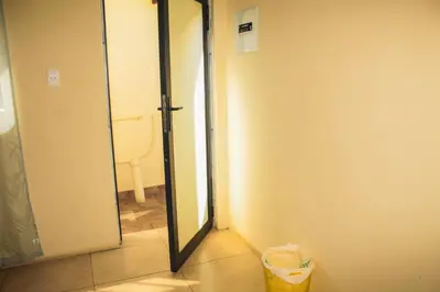 an open door to a bathroom with a trash can at Ingwenya Guesthouse in Ermelo
