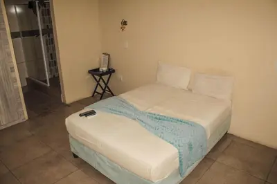 a bedroom with a bed with a phone on it at Ingwenya Guesthouse in Ermelo