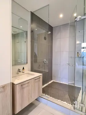 a bathroom with a sink and a glass shower at Luxurious Menlyn Maine 1 Bedroom on 12th Floor with Stunning Views & No Load Shedding in Pretoria
