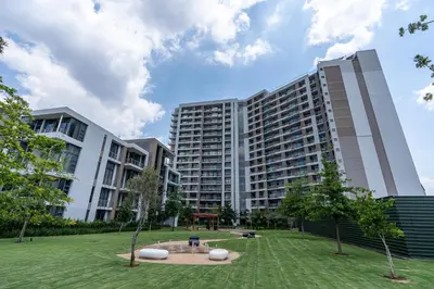 a large building with a park in front of it at Luxurious Menlyn Maine 1 Bedroom on 12th Floor with Stunning Views & No Load Shedding in Pretoria