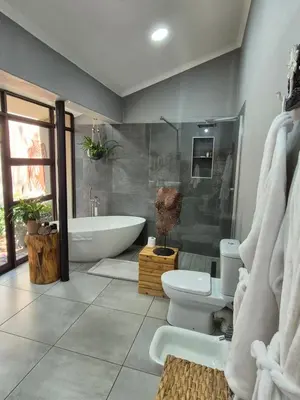 a bathroom with a tub and a toilet and a sink at Bendor Garden Flat in Polokwane