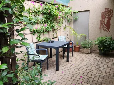 a table and chairs on a patio with plants at Bendor Garden Flat in Polokwane