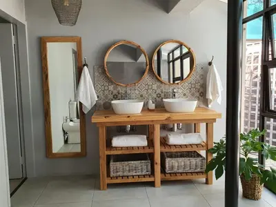 a bathroom with two sinks and two mirrors at Bendor Garden Flat in Polokwane