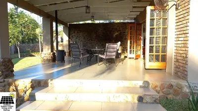 a patio with a table and chairs on it at SnL Guesthouse at Visarend in Malelane
