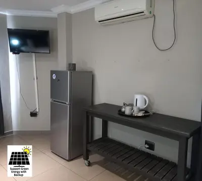 a small kitchen with a refrigerator and a table at SnL Guesthouse at Visarend in Malelane