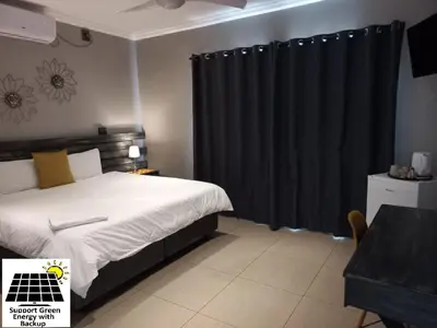 a bedroom with a bed and a black curtain at SnL Guesthouse at Visarend in Malelane