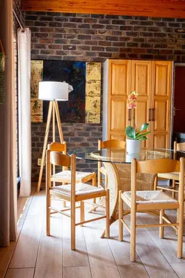 a dining room with a glass table and chairs at Boekenhout Accommodation in Pretoria