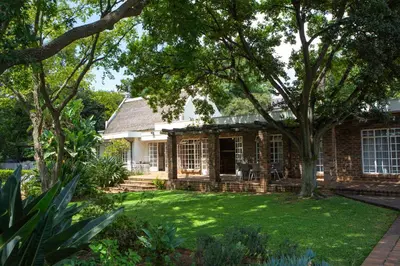 a brick house with a lawn in front of it at Boekenhout Accommodation in Pretoria
