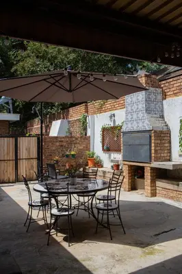 a table and chairs with an umbrella in a patio at Boekenhout Accommodation in Pretoria