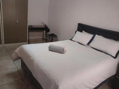 a large white bed with a pillow on top of it at Bambati residence in Soshanguve