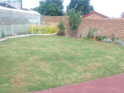 a backyard with a lawn with a fence at Bambati residence in Soshanguve