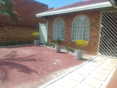 a brick house with a patio with potted plants at Bambati residence in Soshanguve