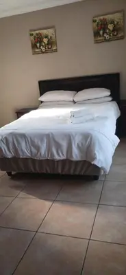 a bed with white sheets and pillows in a bedroom at Hilo guesthouse in Witbank